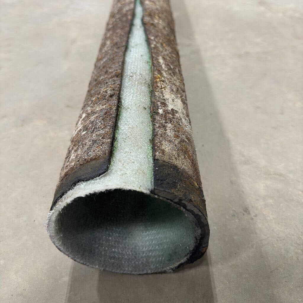 Cross-section of a corroded cast iron pipe with a new cured-in-place liner installed inside
