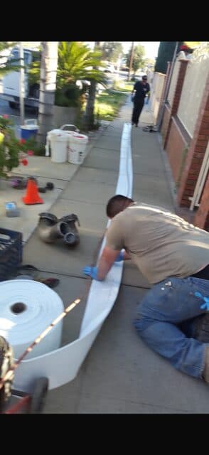 CIPP liner being installed through a sidewalk access point for trenchless sewer rehabilitation